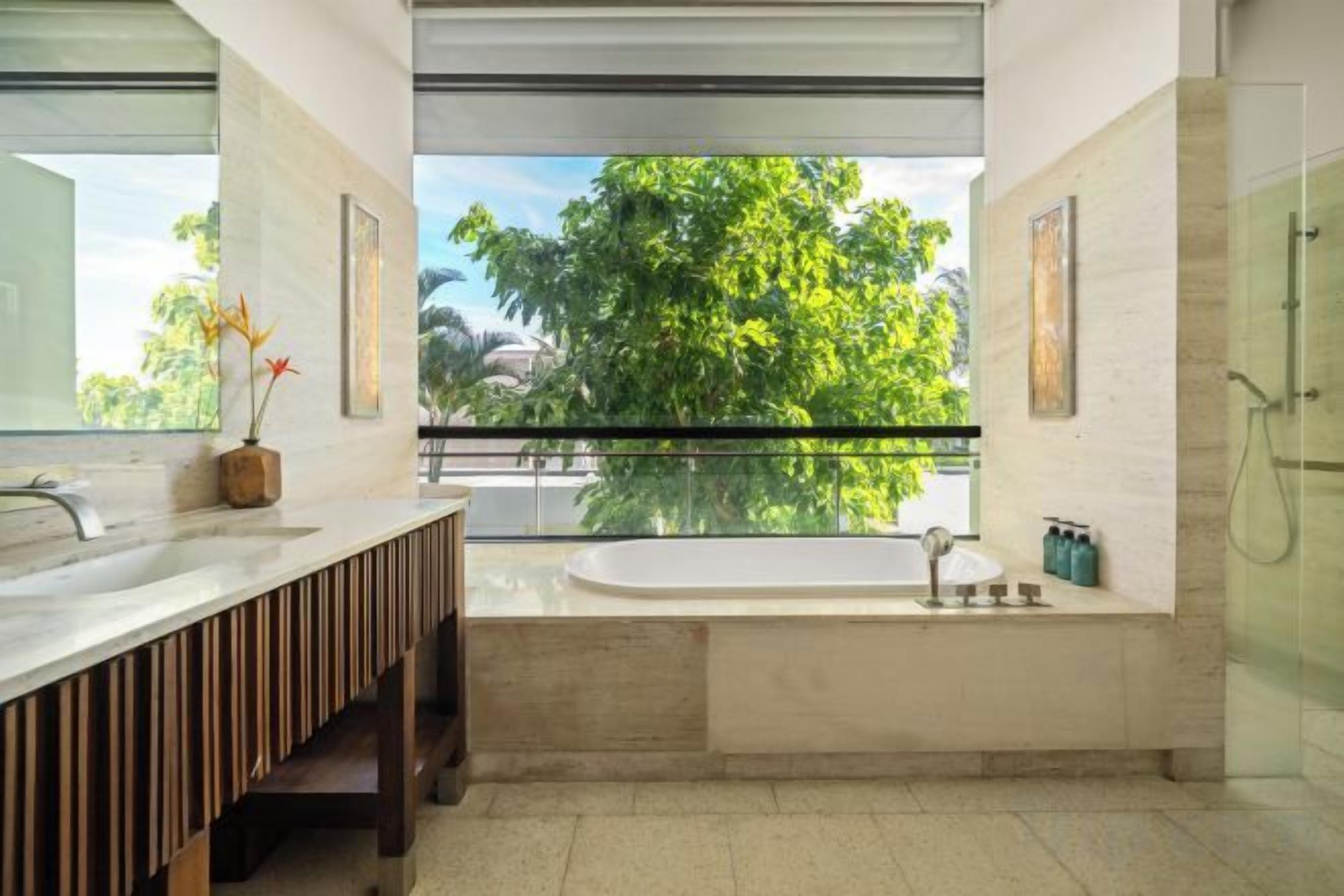 A modern bathroom with a large window, a bathtub, and a shower.