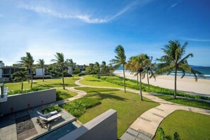 A resort with a swimming pool, palm trees, and a beach view. - Beachfront Villas Resort Danang (Da Nang)