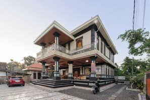 A two-story house with a balcony, a driveway, and a parked motorcycle. - RedDoorz @ Pondok Kampung Harmony Ubud (Bali)