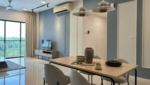A modern dining area with a large table, chairs, and pendant lighting.