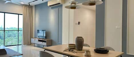 A modern dining area with a table, chairs, and a television in the background.