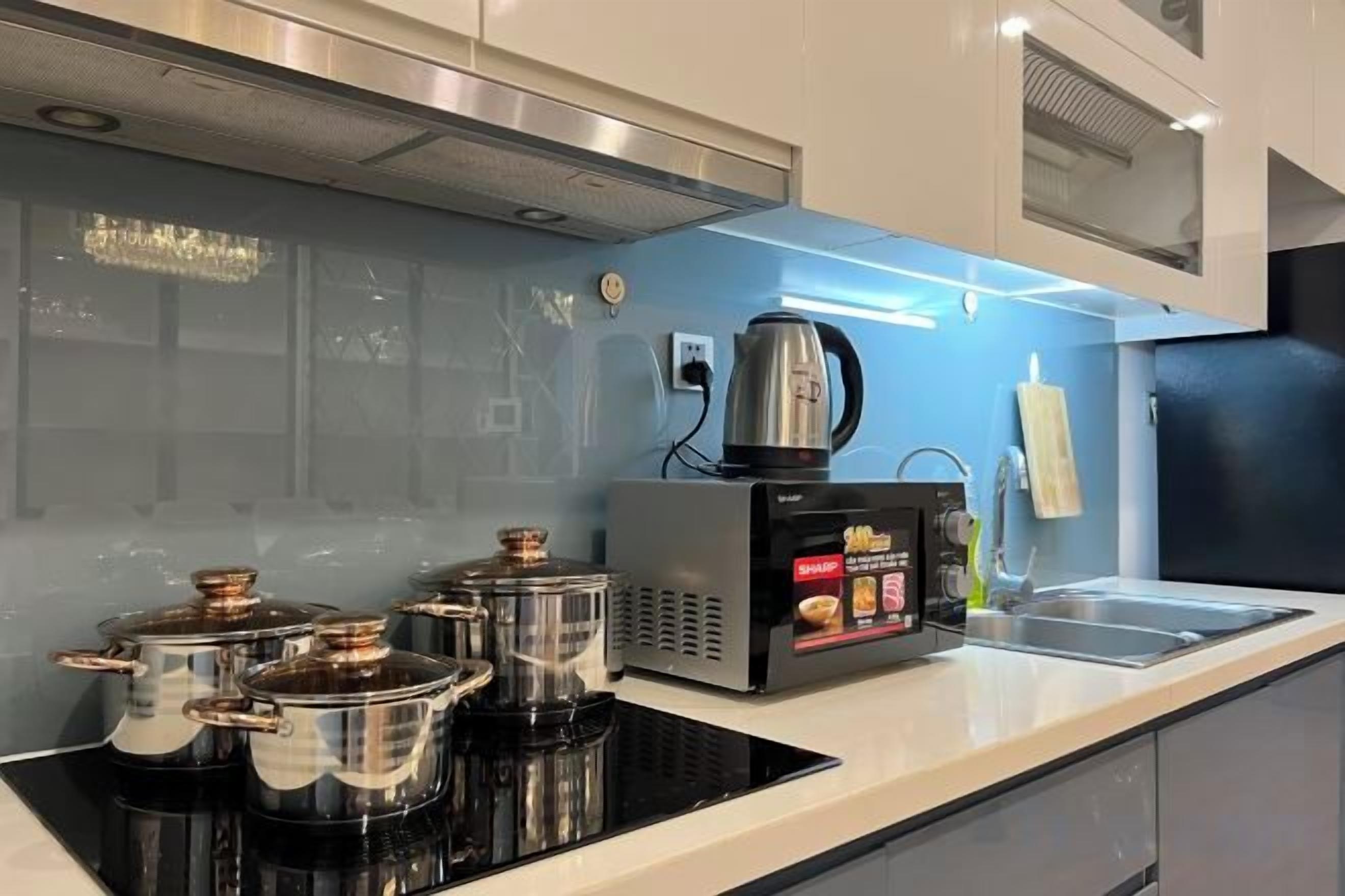 Une cuisine moderne équipée d’une cuisinière intégrée, d’une machine à café et d’une bouilloire.