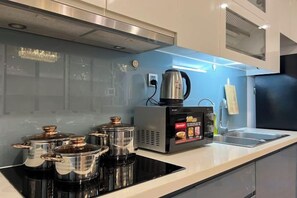 Une cuisine moderne équipée d’une cuisinière intégrée, d’une machine à café et d’une bouilloire.