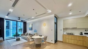 A modern apartment with a dining area, kitchen, and large windows. - Vinhome Metropolis Luxury Apartment - Tiramisu House (Hanoi)