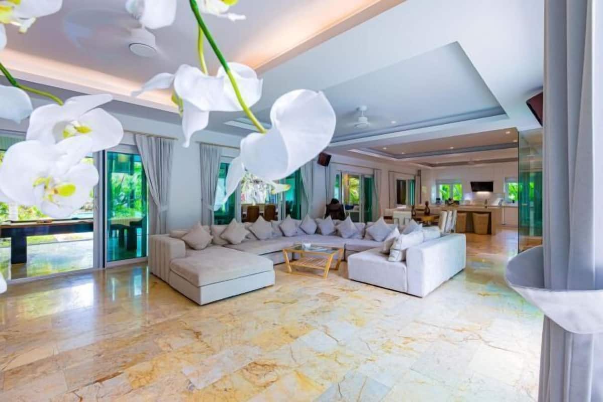 A spacious living area with a large sectional sofa, a coffee table, and a view of the outdoors.