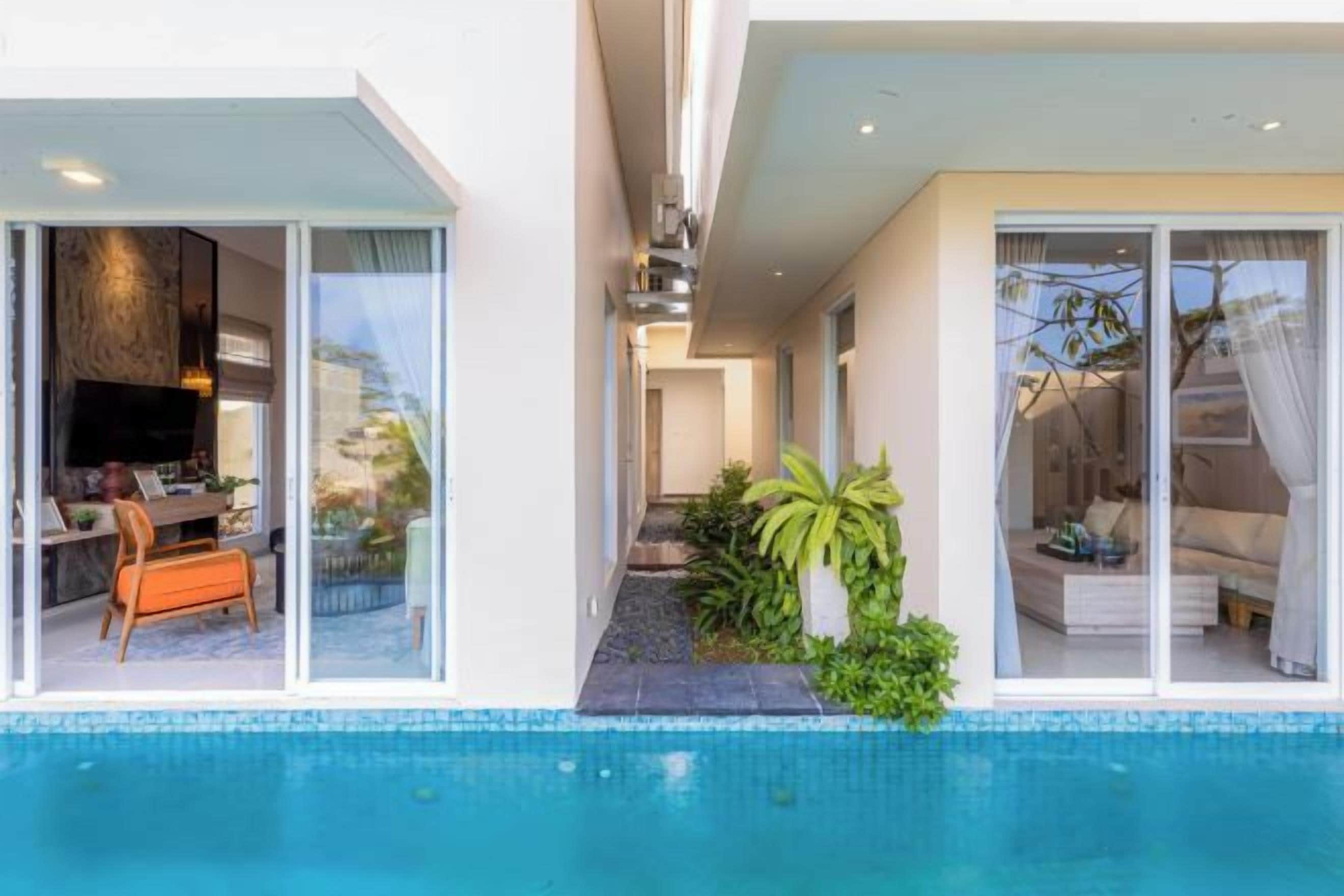 A modern house with a swimming pool, a dining area, and a bedroom with a large window.