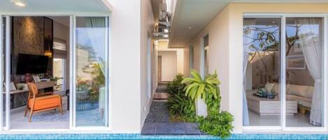 A modern house with a swimming pool, a dining area, and a bedroom with a large window.
