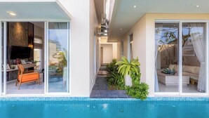 Ein modernes Haus mit Swimmingpool, Essbereich mit Tisch und Stühlen sowie Wohnzimmer mit Sofa.