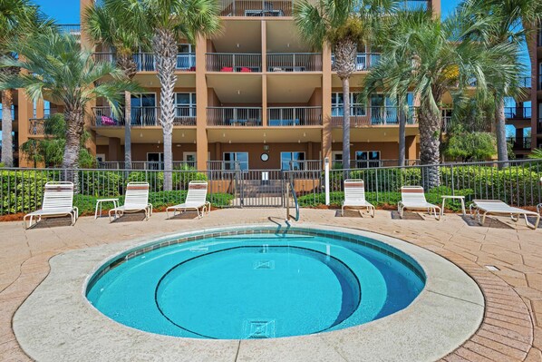 A swimming pool with lounge chairs and palm trees in front of a multi-story building. - Top Floor, Beachfront, Bch Svc, Pool, Grill, Kitchen, Wifi Mediterranea! (Miramar Beach)