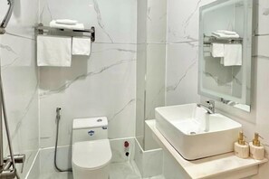 Ein modernes Badezimmer mit Toilette, Waschbecken und Dusche.
