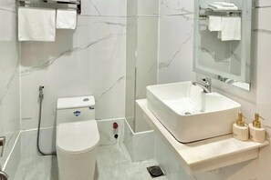 Une salle de bain moderne avec des toilettes, un lavabo et un miroir.