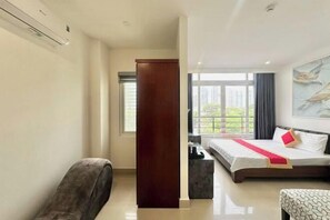 A modern hotel room with a large bed, a seating area, and a view of the outdoors. - Phú Gia 464 Nguyen Van Linh (Ho Chi Minh City)