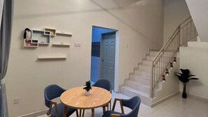 A modern interior with a staircase, a dining area with a round table and chairs, and wall-mounted shelves. - Entire Vacation House In Sitiawan (Sitiawan)