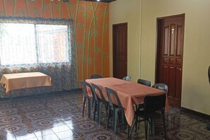 Comedor con mesa y sillas, ventana con persianas y paredes con diseño.
