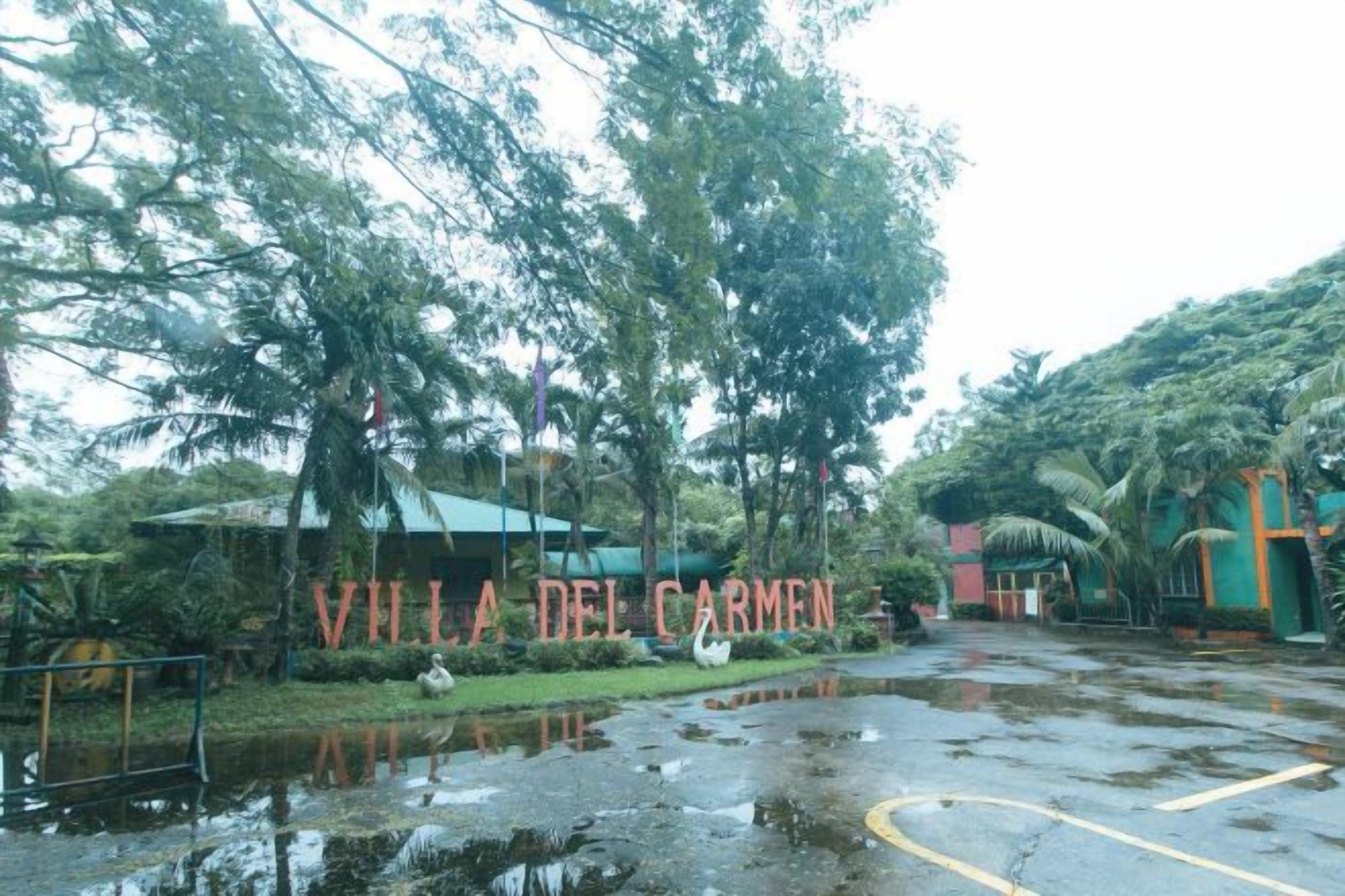 Un área de estacionamiento mojada con un letrero que dice 'Villa del Carmen'.
