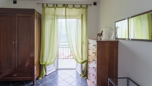 A room with a wooden wardrobe, a dresser, and a mirror on the wall. - Lovely Apartment Overlooking the Lake (Carate Urio)