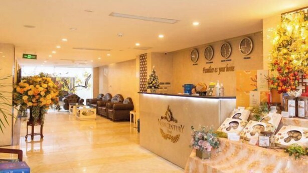 A reception area with a counter, a clock, and a floral arrangement. - NEW CENTURY HOTEL LANG SON (Lang Son)