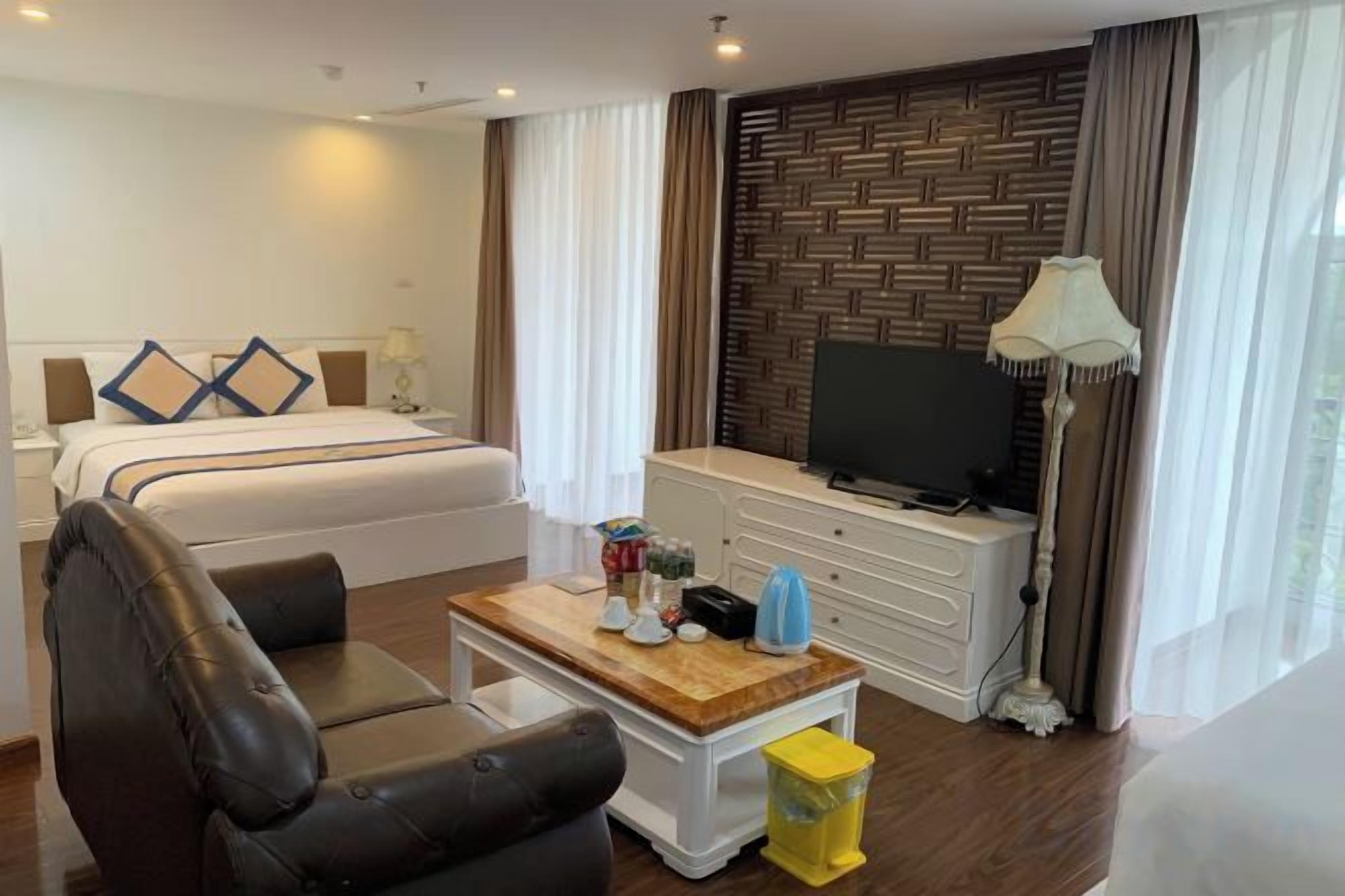 Une chambre d’hôtel équipée d’un lit, d’un bureau, d’une chaise, d’une télévision et d’une lampe.