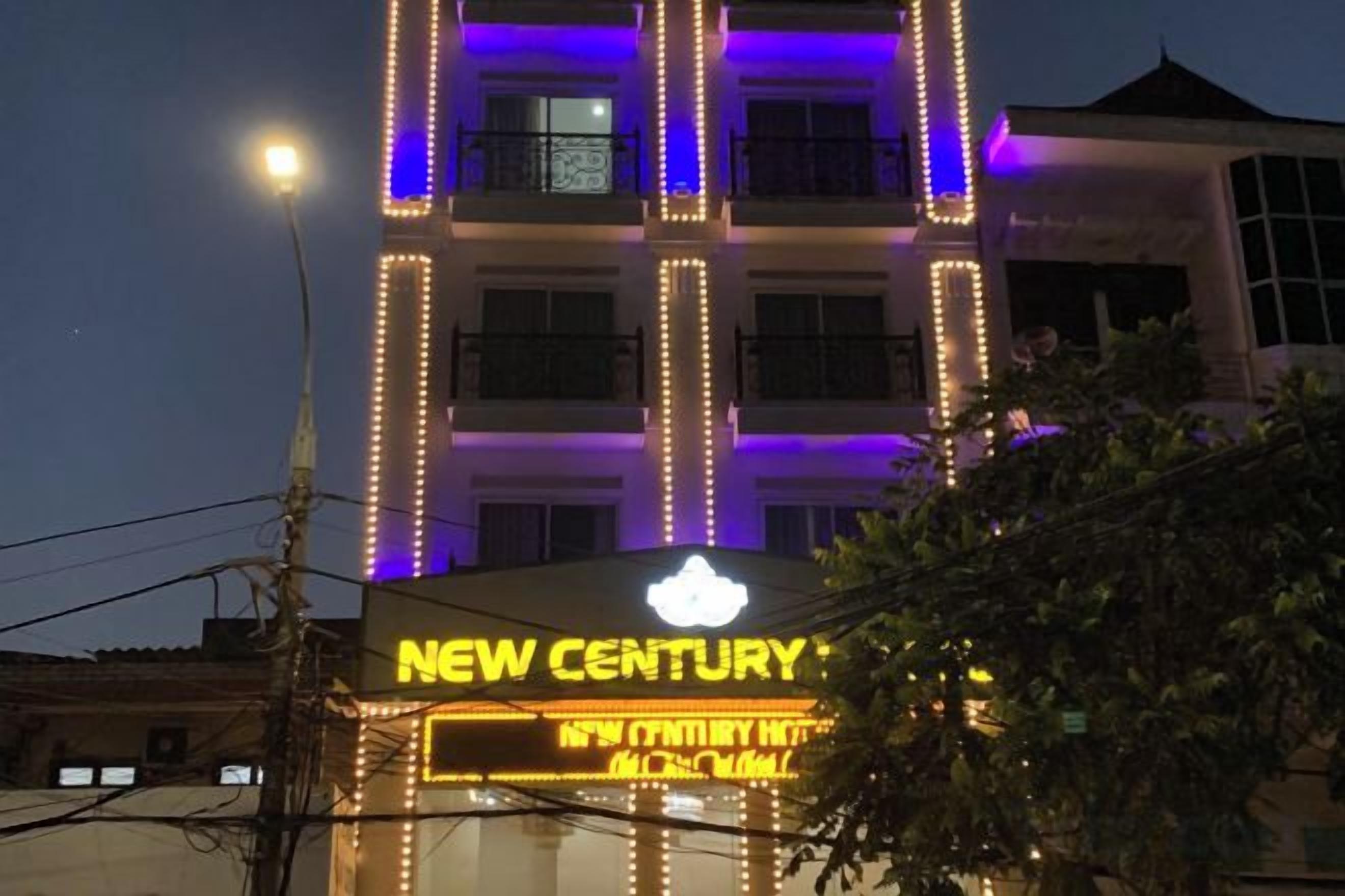 A hotel with illuminated signage, multiple floors, and a balcony.