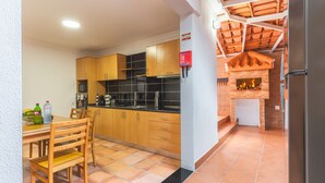 Une cuisine de taille réduite, avec des meubles en bois, un plan de travail noir et un sol carrelé.