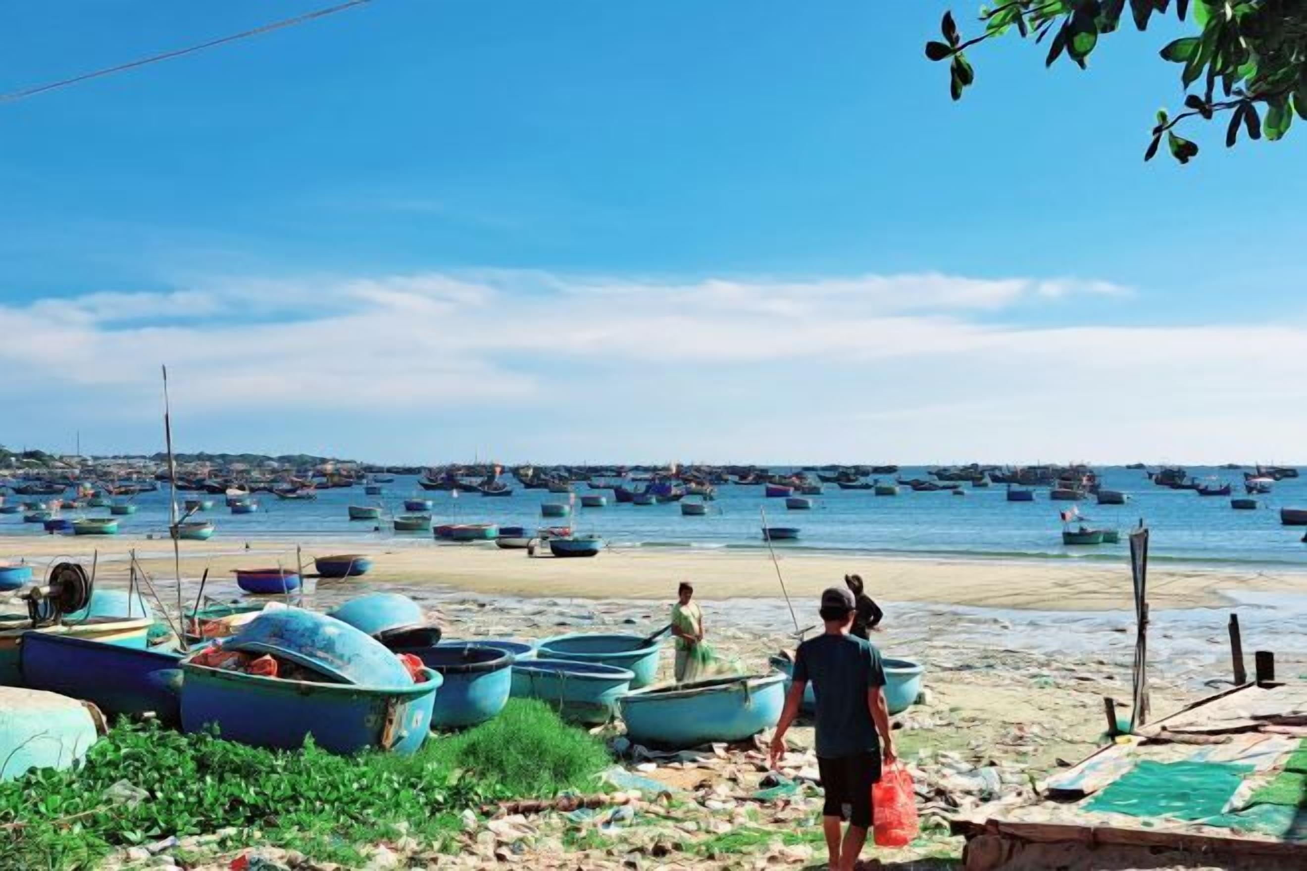A beach with boats and a clear sky.