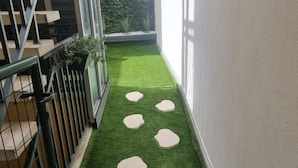 A narrow corridor with artificial green flooring and white stepping stones. - Apartment Centre Carmes (Toulouse)