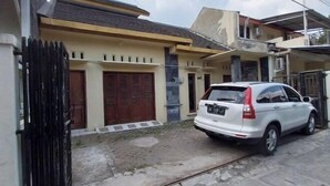 A residential building with a white car parked in front.