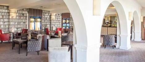 Une bibliothèque dotée d’étagères, de sièges et d’un espace bar.