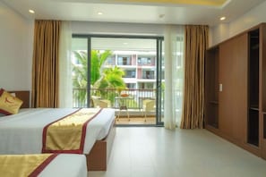A hotel room with a balcony, a bed, a wardrobe, and a table with chairs. - Anise hotel (Phu Quoc Island)