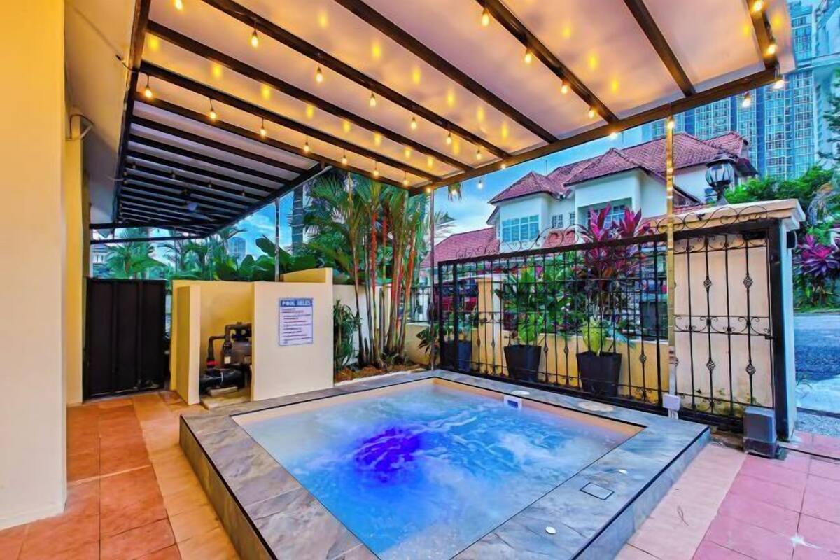 Un espace bien-être comprenant un jacuzzi, un coin salon abrité et une vue sur les immeubles résidentiels.