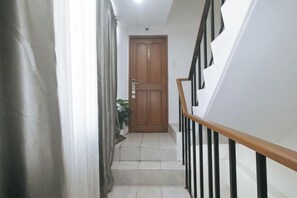 A staircase with a wooden handrail and a closed wooden door at the top. - GREN PLACE near Baclaran Airport Road by RedDoorz (Paranaque)