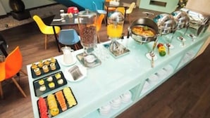 Disposição de buffet com diversos alimentos e bebidas.