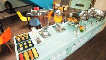A buffet setup with various food items and beverages.