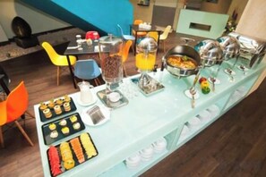A buffet setup with various food items and beverages. - Idoop Hotel by Prasanthi (Pejanggik)