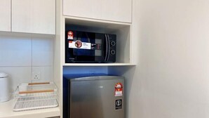 A kitchen with a microwave and a stainless steel refrigerator. - Chambers Residence by Manhattan Group (Kuala Lumpur)