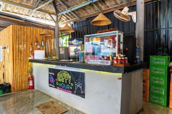 A bar area with a 'Happy Hour' sign, a counter with various items, and a fire extinguisher.