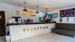 A reception area with a counter labeled "RECEPTION," a sofa, and a wall with a sign that reads "Vang Vieng Chill House." - Vang Vieng Chill House (Vang Vieng)