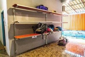 Bunk beds with storage shelves, a visible window, and a view of an outdoor area.