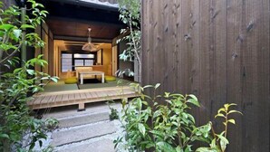 Una habitación tradicional japonesa con suelo de tatami, una mesa de madera baja y una lámpara colgante.