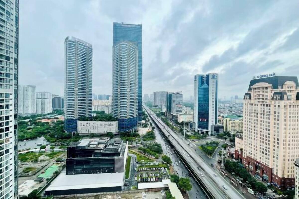 Paisagem urbana com edifícios altos e modernos, uma autoestrada e uma variedade de edifícios comerciais e residenciais.
