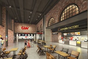 A spacious indoor area with tables and chairs, a popcorn factory snack bar, and a CGN store. - Flora Urban - Premium Apartment Vinhomes Skylake Near Keangnam (Hanoi)