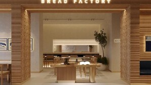 A Bread Factory restaurant with a modern interior, featuring wooden accents and a central dining table. - Flora Urban - Premium Apartment Vinhomes Skylake Near Keangnam (Hanoi)
