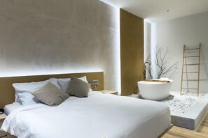 A modern bedroom with a large bed, bedside tables, a white bathtub, and a ladder against the wall. - Quill Residences A by Favspace (Kuala Lumpur)