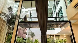 A modern indoor space with large windows, indoor plants, and a pool area. - 189/7bangkok 6 bedrooms private pool villa，1000square summer villa (Bangkok)