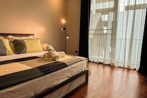A neatly made bed with pillows and a blanket, a bedside lamp, and a window with sheer curtains. - 189/7bangkok 6 bedrooms private pool villa,1000square summer villa (Bangkok)