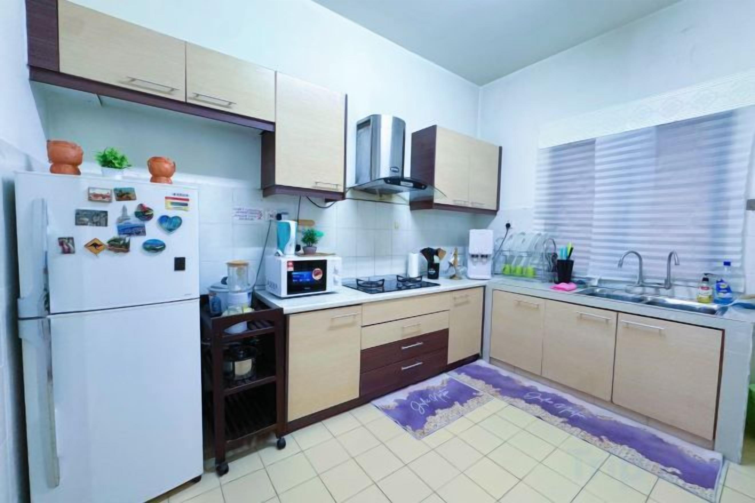 Una cocina compacta equipada con refrigerador, microondas, estufa y lavamanos.