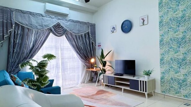 Una sala de estar moderna con sofá, televisor y plantas decorativas.