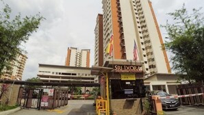 Entrada de hotel con un letrero, un camino con puerta de acceso y un coche estacionado.