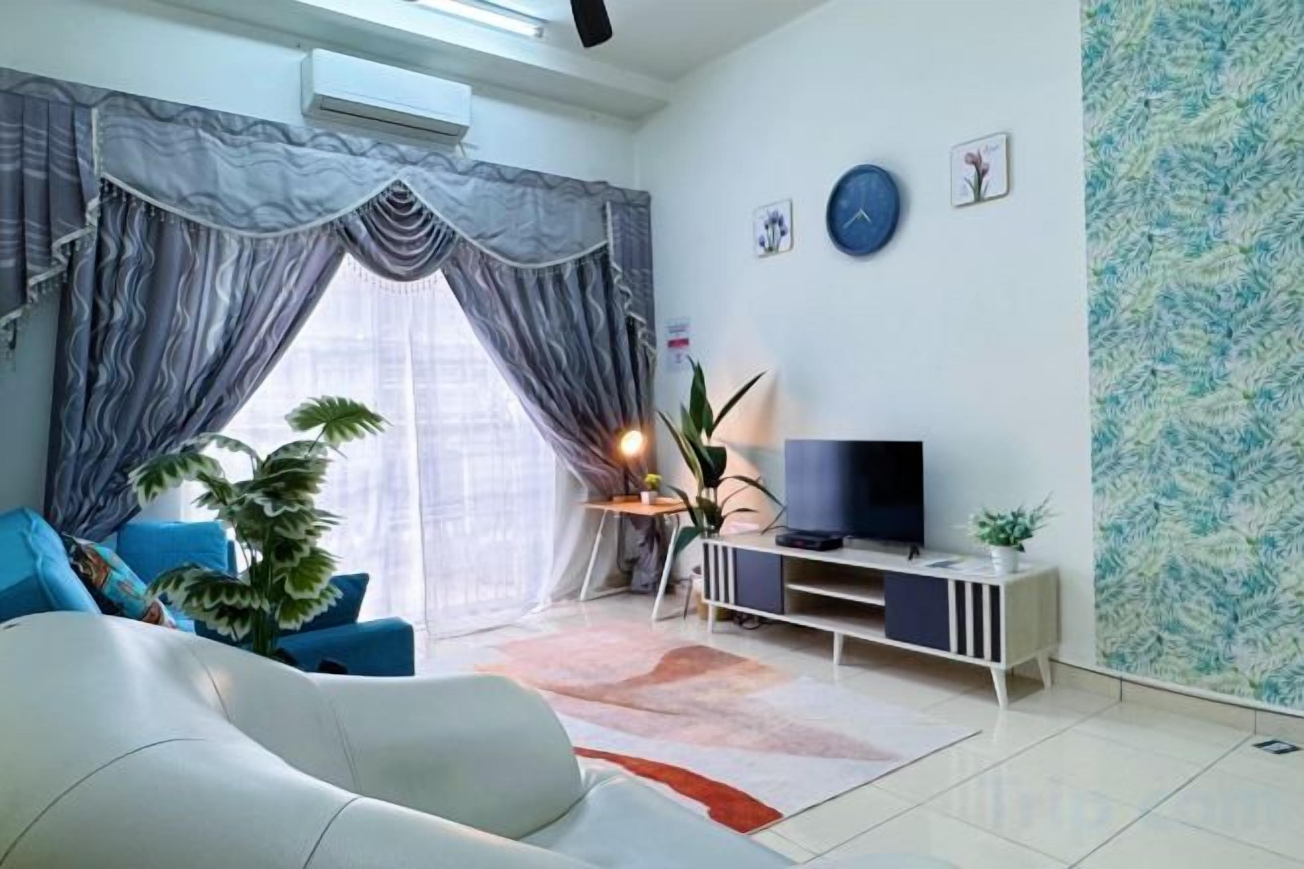 Una sala de estar moderna con sofá, televisor y plantas decorativas.