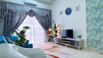 Una sala de estar moderna con sofá, televisor y plantas decorativas.